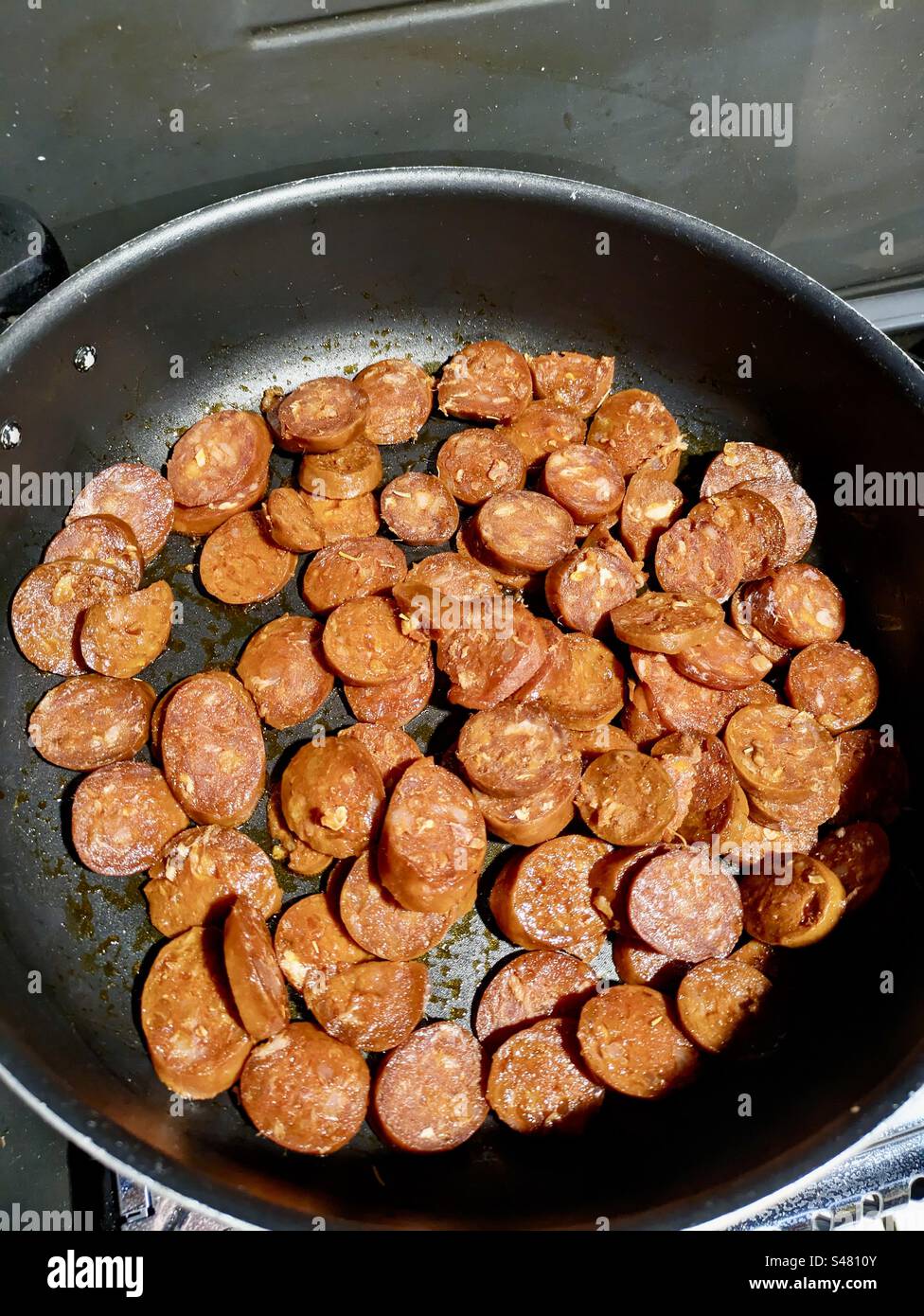 Chorizo fresco in preparazione friggitrice cucinare cucinare cibi cotti farina di erbe aromatiche padella per friggere aglio caldo gustoso yum delizioso sud della Francia primo piano carne di maiale maiale Foto Stock