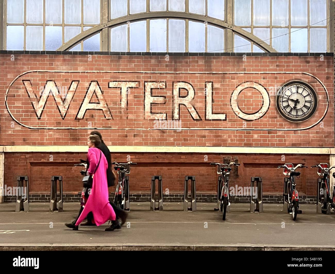 Passeggia accanto all'orologio esterno della stazione ferroviaria di Waterloo Foto Stock