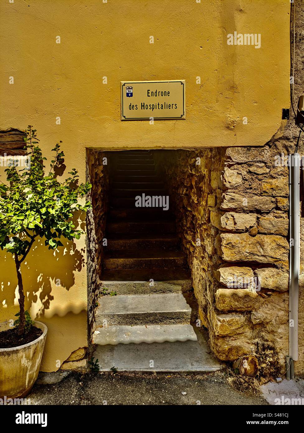 Strada pedonale a Greoux les Bains, segnaletica "endrone des Hospitaliers" case Provenza strada rustica strada rocciosa strada tranquilla strada principale marciapiede scale a sud della Francia 12-6-23 Foto Stock