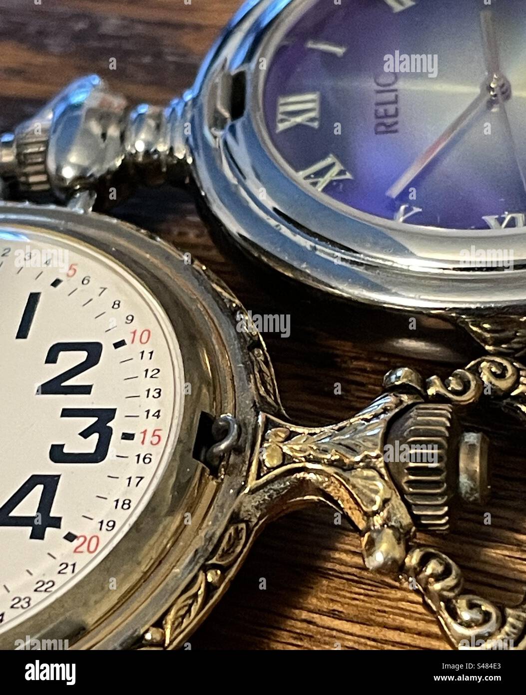 Due orologi da tasca dallo stile diverso che mostrano i tempi sui loro volti in natura morta. Foto Stock