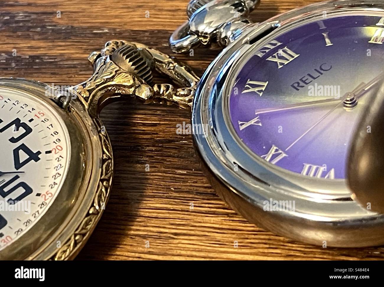 Due orologi da tasca dallo stile diverso che mostrano i tempi sui loro volti in natura morta. - Immagine stock catturata con smartphone
