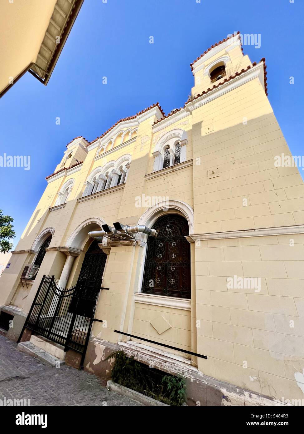 Facciata gialla della Santa Chiesa dei grandi Tassiarchi e della Vergine Maria Grigorousa nel quartiere Plaka di Atene, in Grecia. Foto Stock