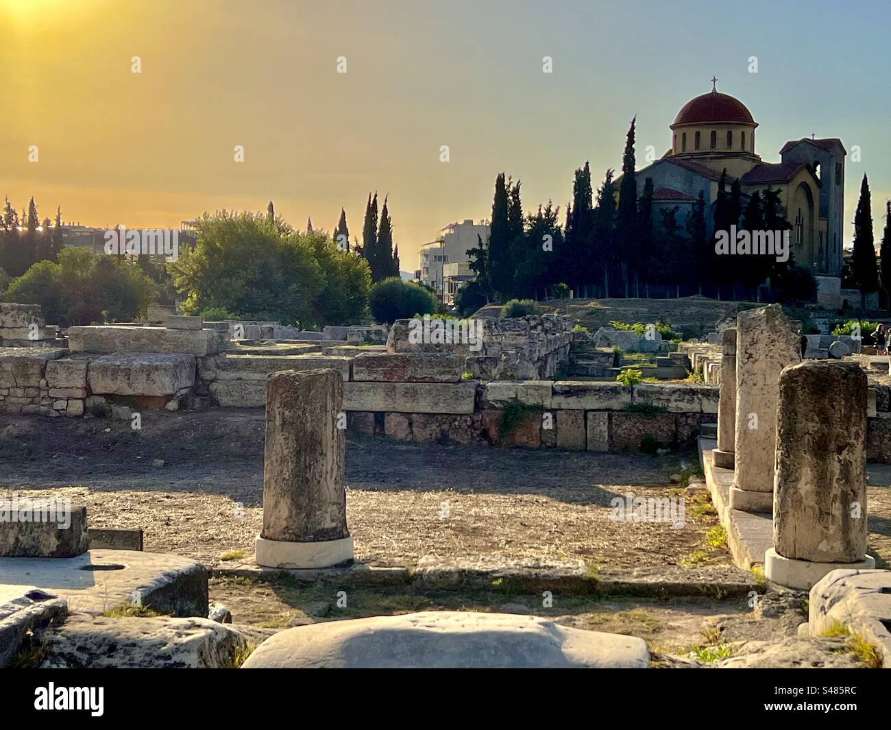 Il sole giallo luminoso di sera è basso nel cielo ad Atene presso l'antico sito delle rovine del cimitero di Kerameikos e il Museo Archeologico di Kerameikos. Foto Stock