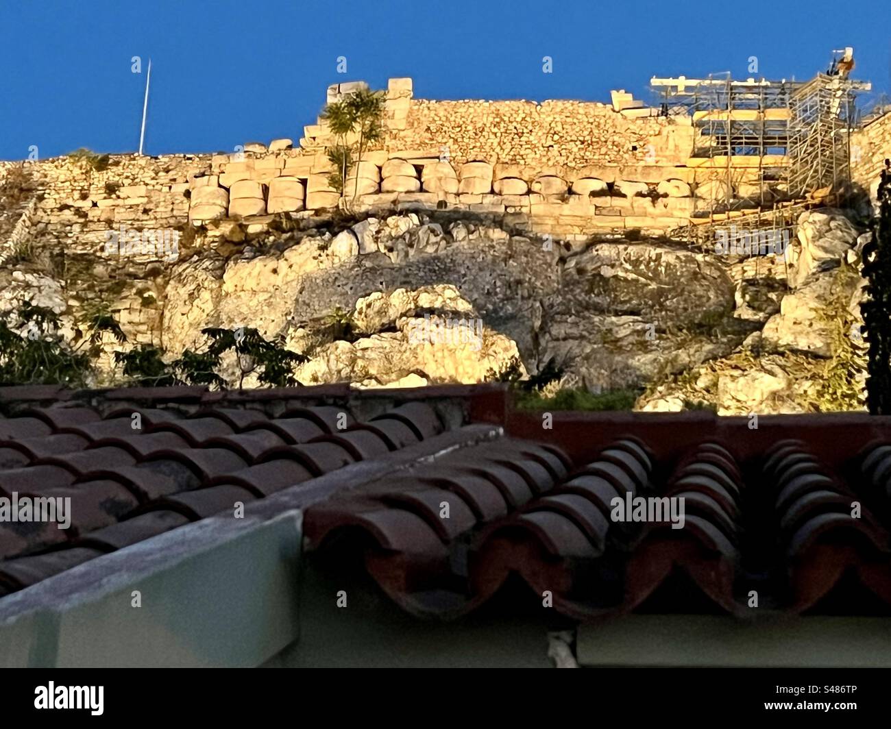 Vista sul tetto di Atene, guardando la collina dell'Acropoli illuminata di sera - Immagine stock catturata con smartphone