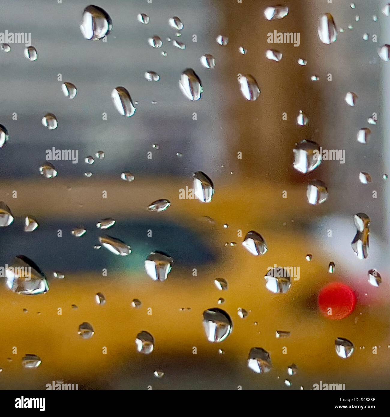 Impressione di un taxi giallo di New York visto attraverso una finestra che spruzza la pioggia Foto Stock