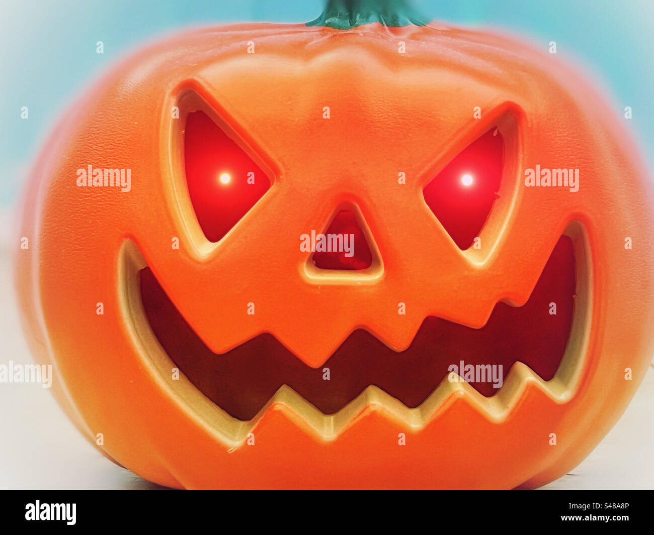 Faccia di zucca di Halloween con occhi rossi accesi Foto Stock