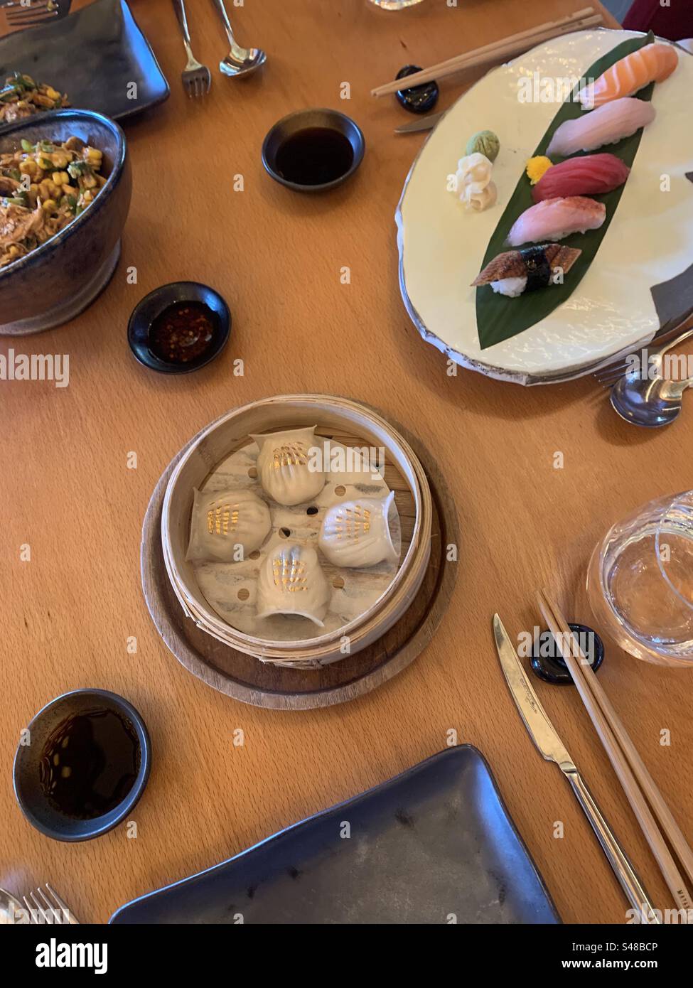 Gamberetti har gau, una selezione di nigiri misti e un'insalata di pollo e mais sminuzzati serviti come antipasti in un ristorante asiatico Foto Stock