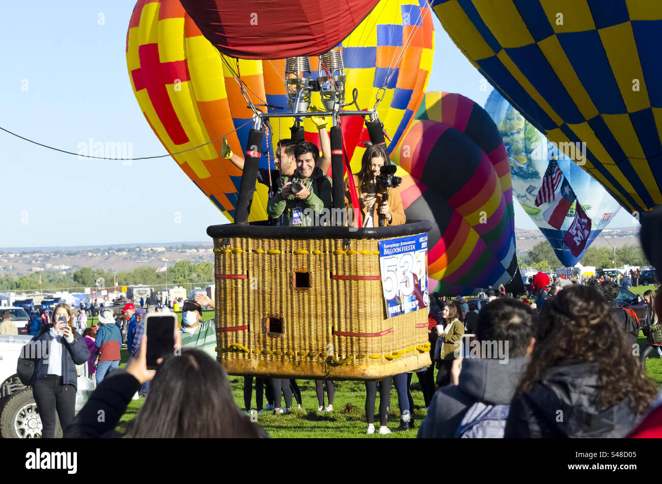 Emozionate le persone in mongolfiera mentre decollano da terra al balloon fiesta di Albuquerque, New Mexico Foto Stock