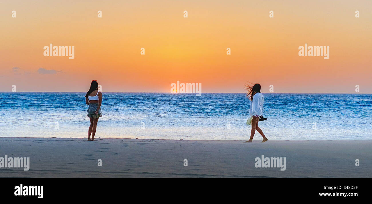 Godersi il tramonto sulla spiaggia Foto Stock