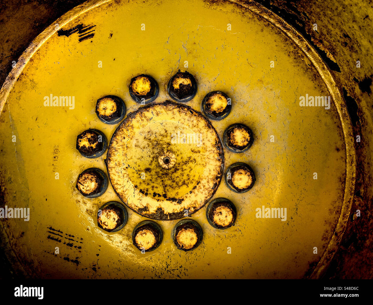 Primo piano del mozzo ruota con i dadi di fissaggio su un trattore - Immagine stock catturata con smartphone