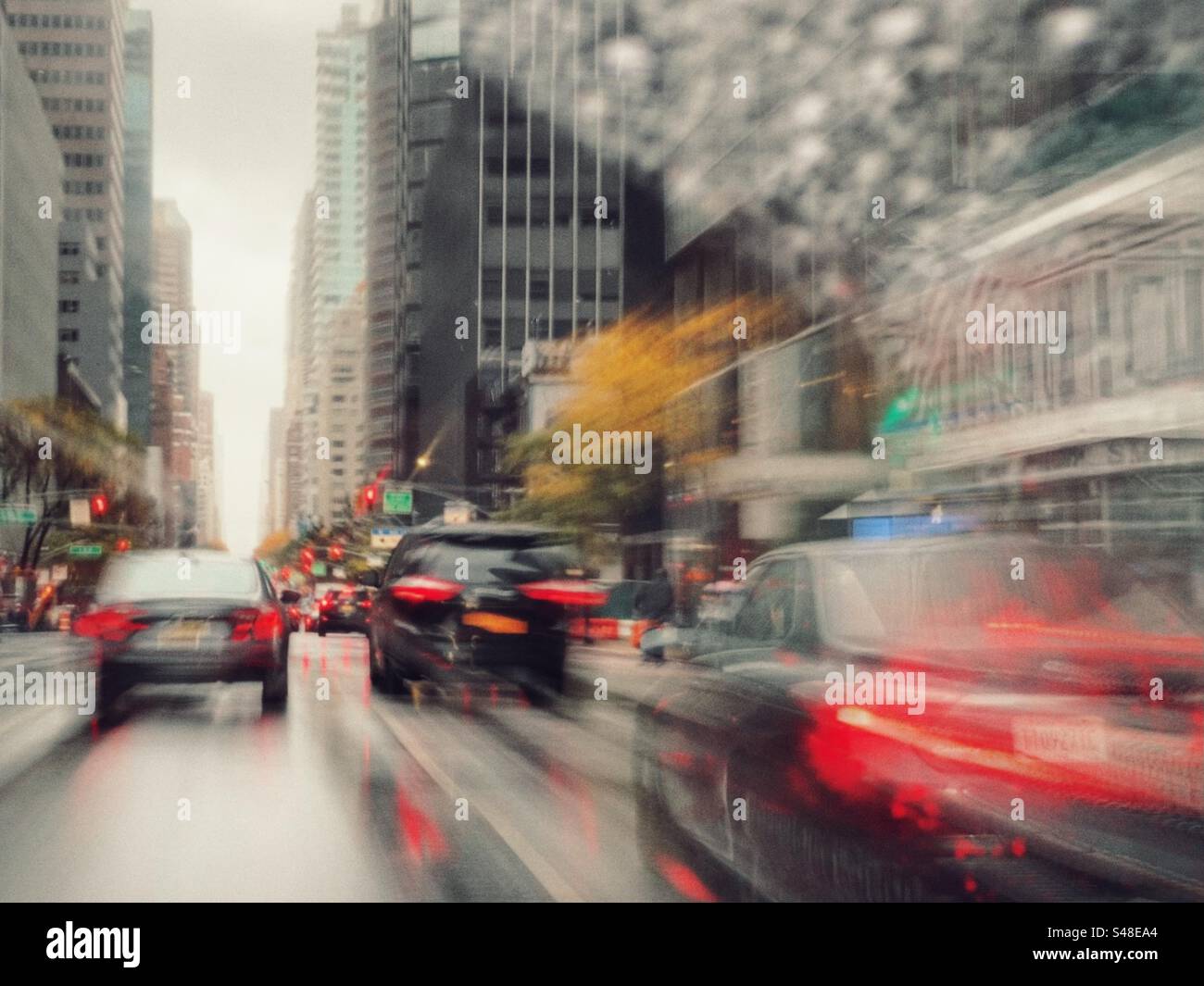 Sentieri leggeri e traffico offuscato sotto la pioggia, New York City - Immagine stock catturata con smartphone