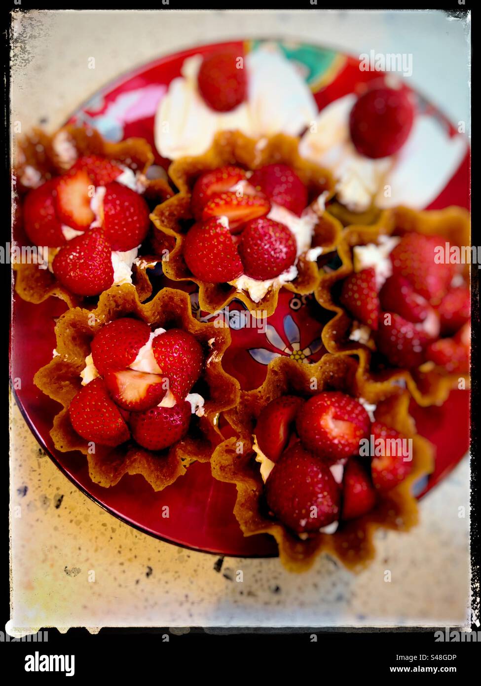 Fragole e panna in cesti di brandy Foto Stock