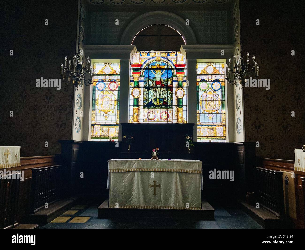 L'altare e le vetrate colorate della chiesa di Santa Maria a Glynde, East Sussex Foto Stock