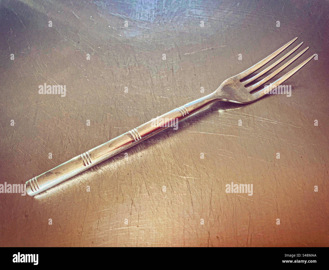 forchetta d'argento su un piatto d'argento in una cucina pronta per essere utilizzata poiché è un piatto lucido pulito per le persone che desiderano mangiare con esso in un ristorante - Immagine stock catturata con smartphone