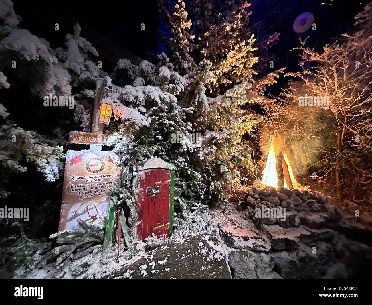 Una porta in miniatura e un falso fuoco incendiati in una scena invernale al parco a tema Liseberg a Gothenburg, Svezia. Foto Stock
