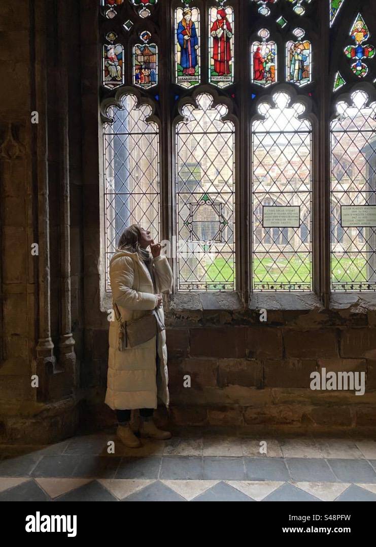 Donna che guarda la finestra della cattedrale Foto Stock