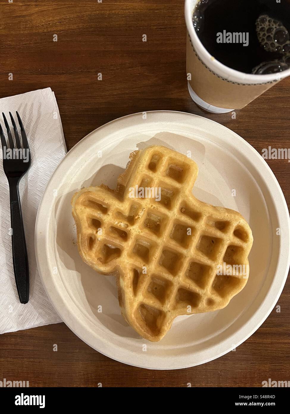 Colazione a base di waffle a forma di Texas su un piatto di carta con una tazza di caffè - Immagine stock catturata con smartphone