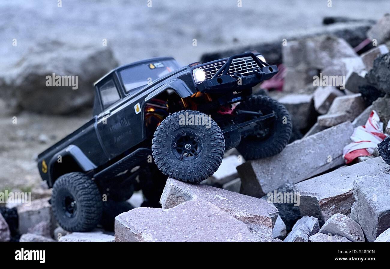 Foto di un cingolato in jeep nero con radiocomando su camion che si arrampica e si inerpica su rocce e blocchi di cenere in Francia Foto Stock