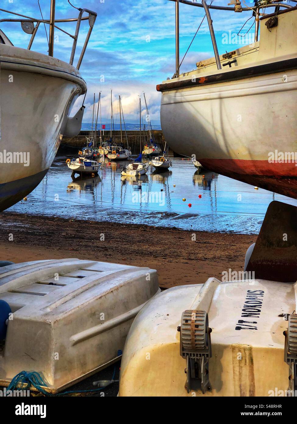 Le barche sul molo di carenaggio sono fuori servizio per manutenzione al porto di Fisherrow, Musselburgh, Scozia - Immagine stock catturata con smartphone