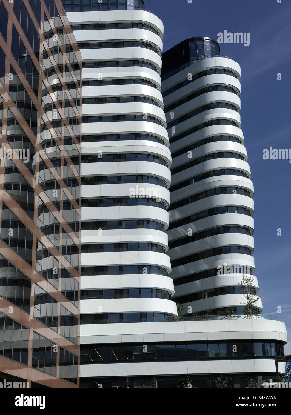 DLD College London (alti edifici bianchi) al sole contro un cielo blu - Immagine stock catturata con smartphone