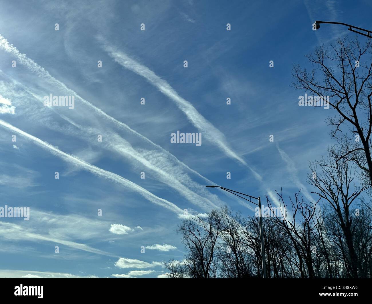 Contrapposizioni persistenti di aeroplani (tracce di vapore o tracce di condensazione) nel cielo. Foto Stock