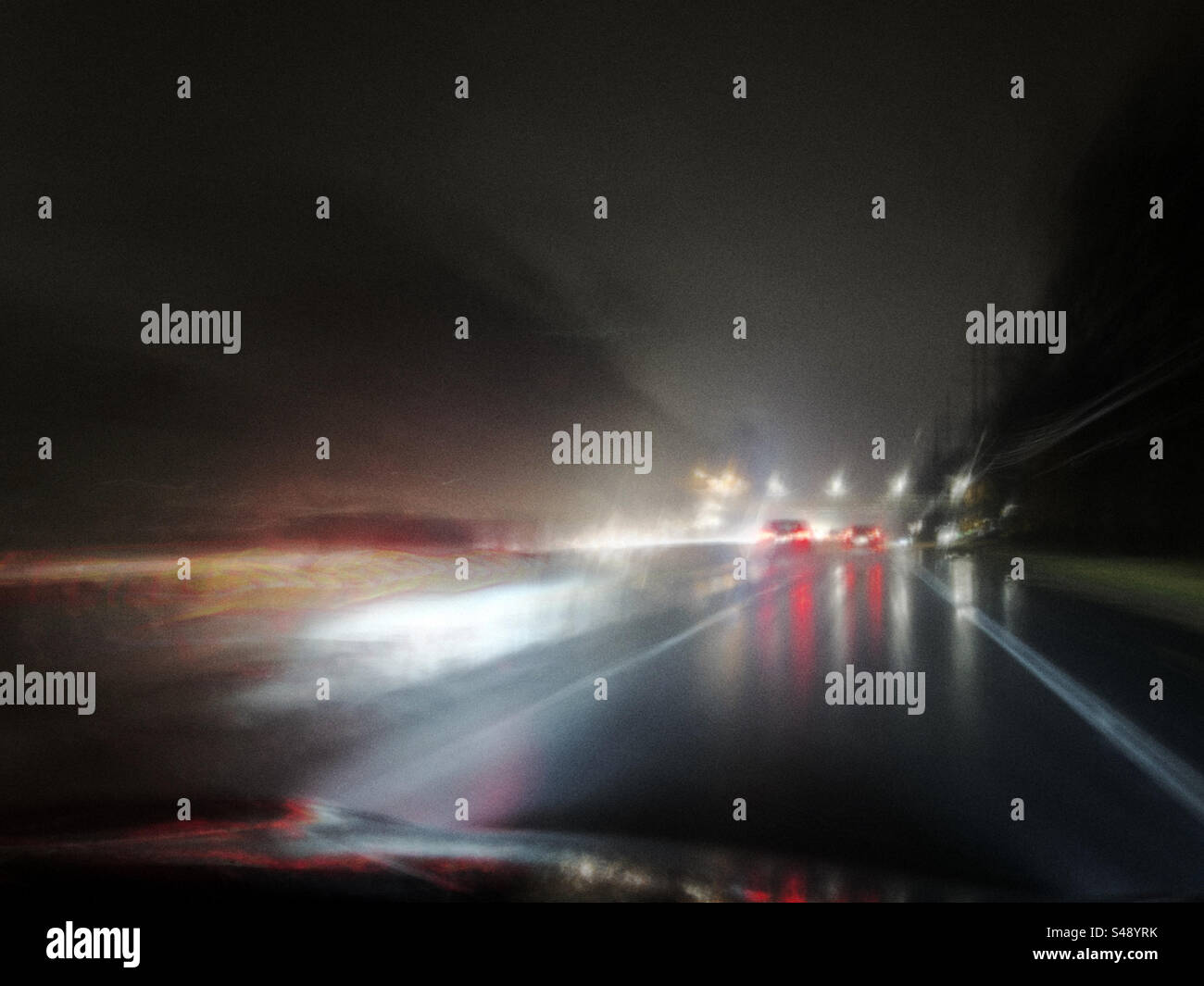 Guida notturna lenta attraverso il New Jersey sotto la pioggia. Foto Stock