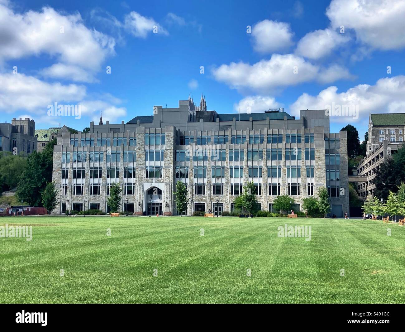 Campus del Boston College durante l'estate con un grande prato di fronte all'edificio in pietra. Chestnut Hill, Massachusetts, USA. Foto Stock