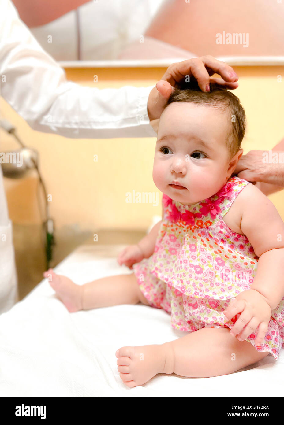 Medico pediatrico che controlla la fontanelle anteriore del bambino Foto Stock