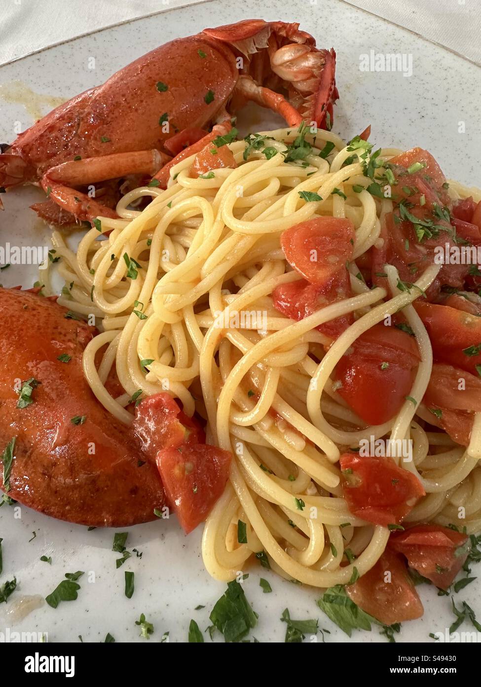 Spaghetti con aragosta e ciliegie di pomodoro al ristorante Foto Stock