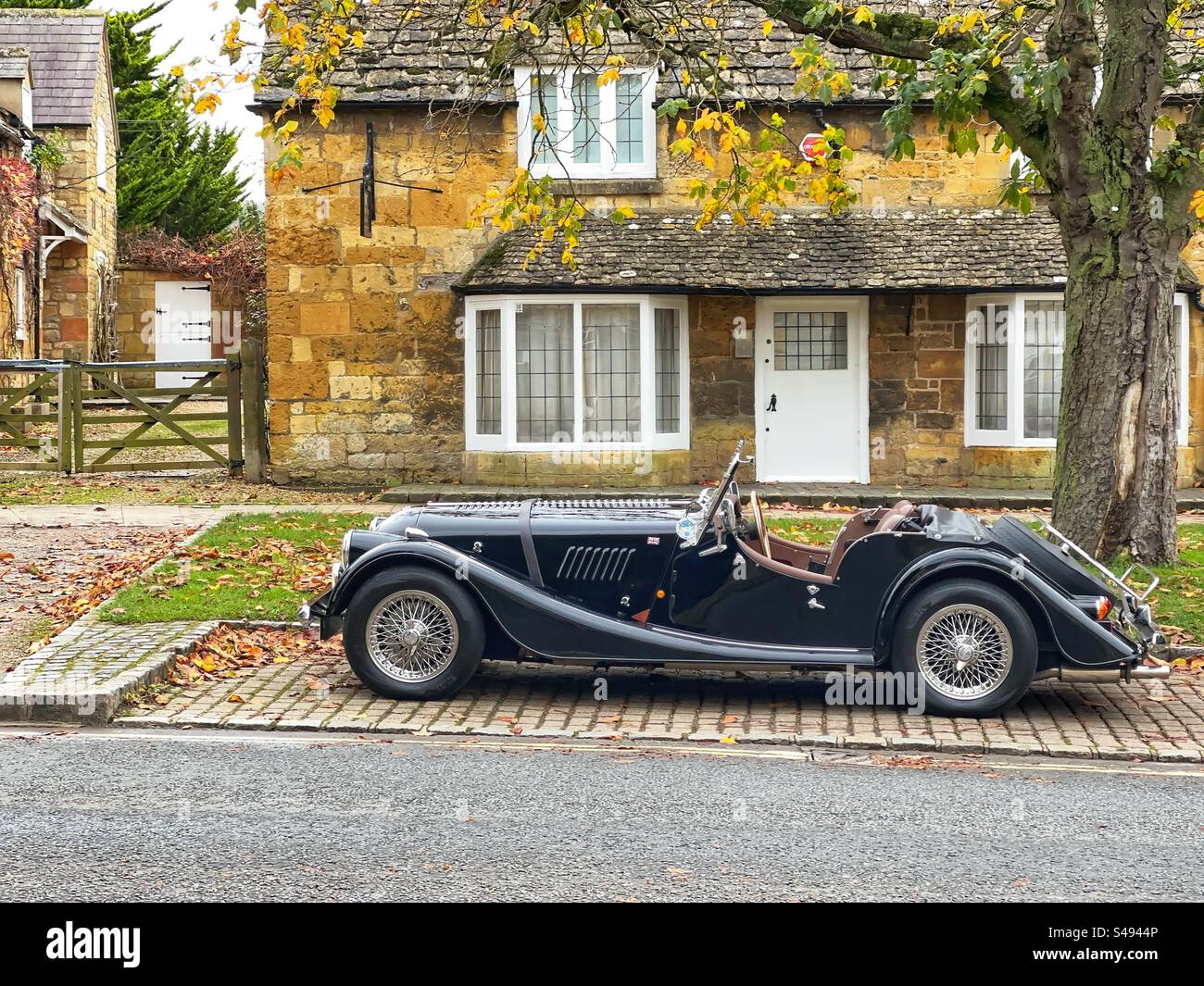Broadway, Cotswolds, Inghilterra, Regno Unito - novembre 2923: Auto sportiva Morgan classica parcheggiata all'esterno di un cottage nel grazioso villaggio Cotswolds di Broadway - Immagine stock catturata con smartphone