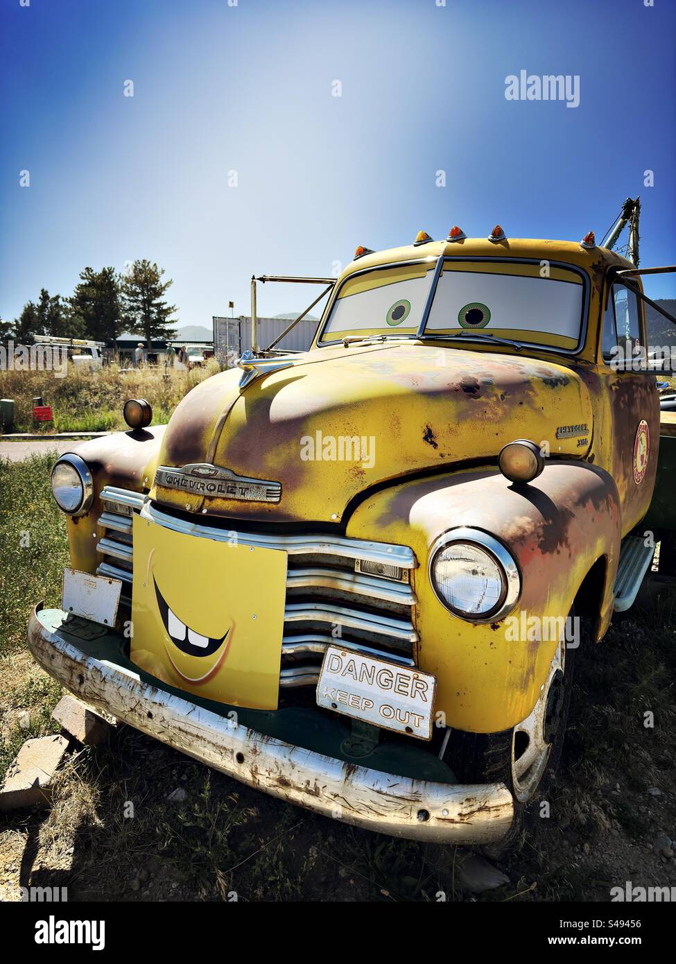 Monster truck giallo con il volto dei personaggi dei cartoni animati in Colorado. Cartello sulla griglia: Pericolo, tenersi fuori. Chevrolet arrugginito, veicolo all'aperto. - Immagine stock catturata con smartphone