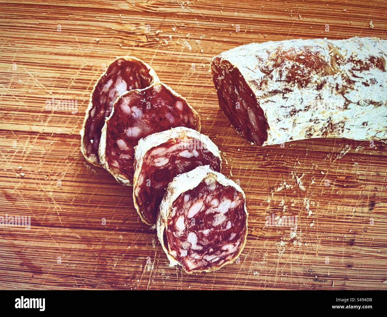 fette di salame salato secco saucisson foid su tavola di legno bianco in cucina pronti per essere mangiati mangiando Foto Stock