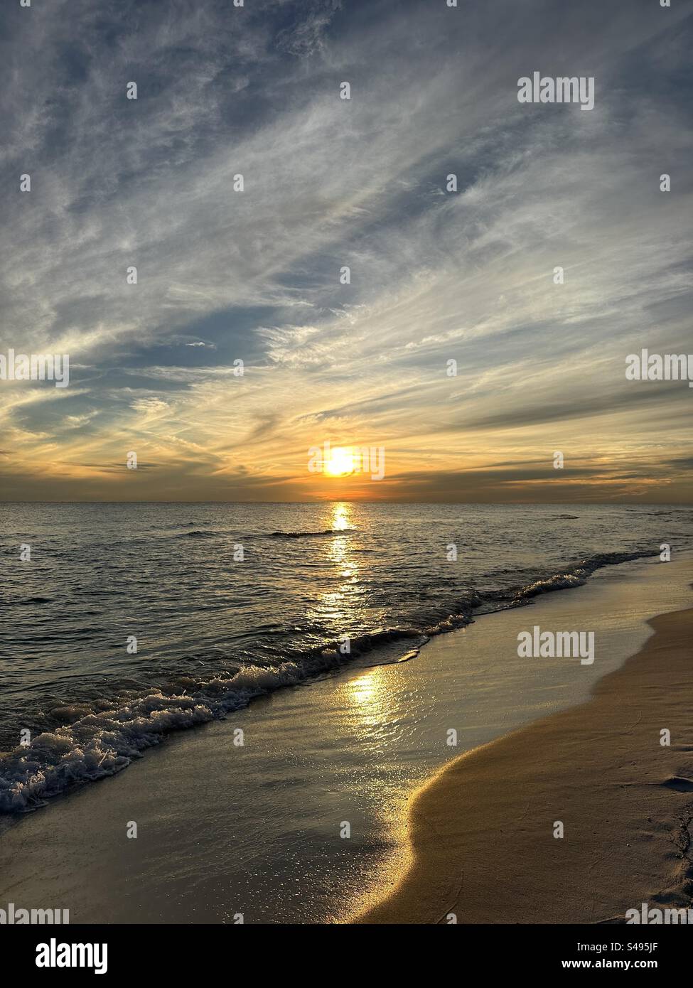 Sole dorato con nuvole che tramontano sulle acque del Golfo del Messico a Miramar Beach in Florida Foto Stock