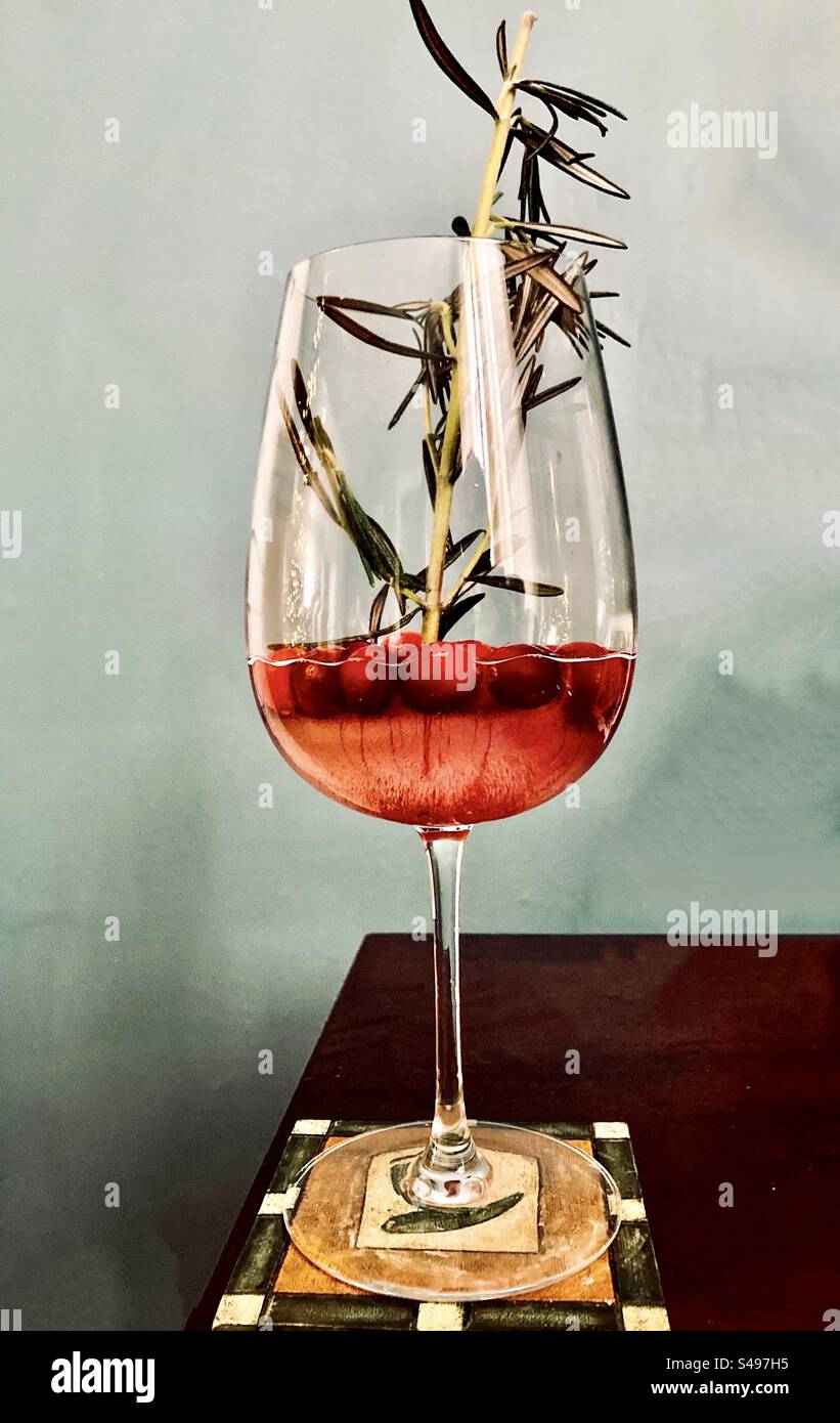 Sorseggiate un drink natalizio con mirtilli rossi e rosmarino. Foto Stock