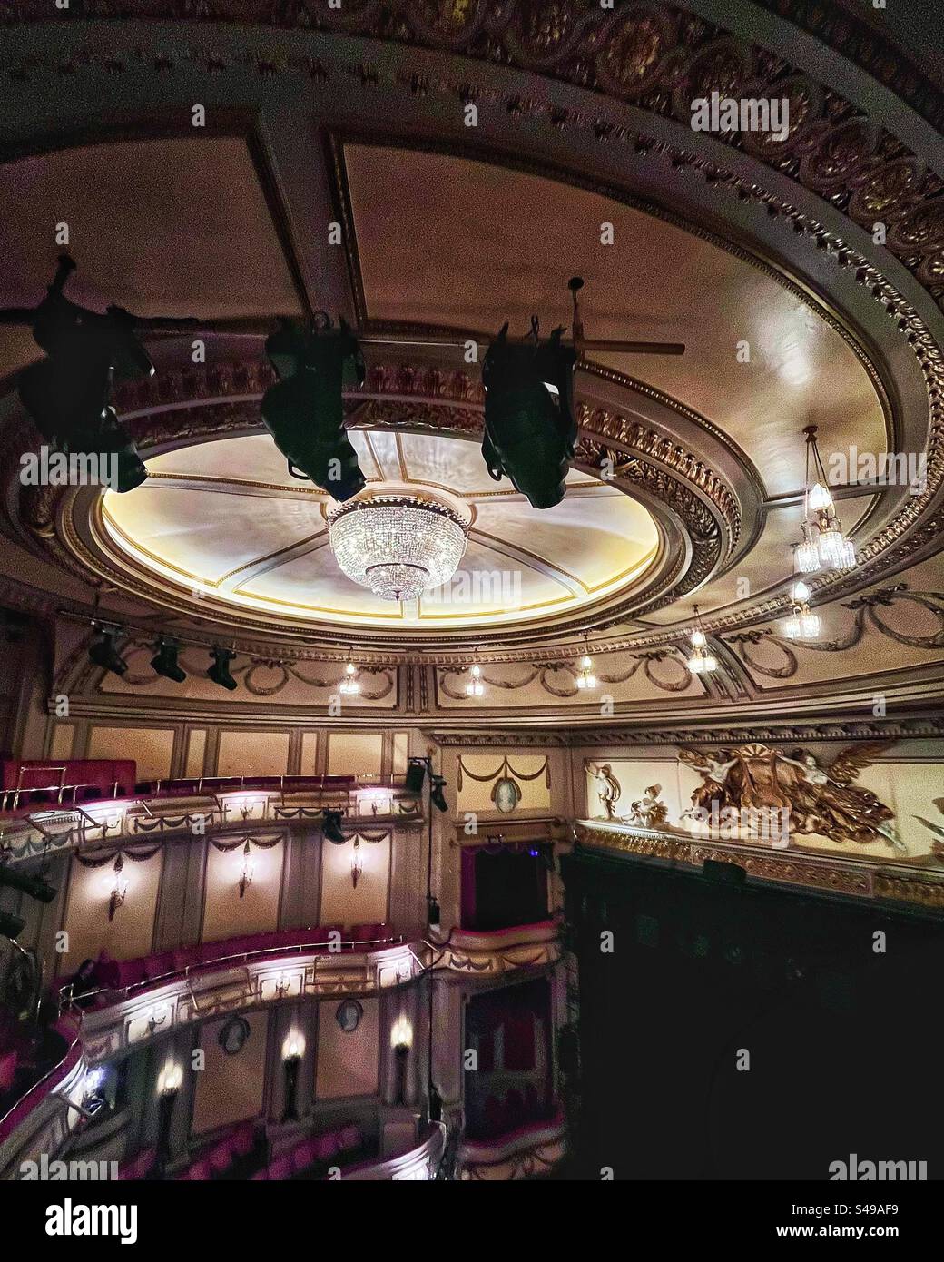 Auditorium del Noël Coward Theatre precedentemente Albery Theatre in St Martin's Lane, Londra. In figura sono mostrati lo stile neo-rococò e il lampadario. Tendine del palco chiuse. - Immagine stock catturata con smartphone