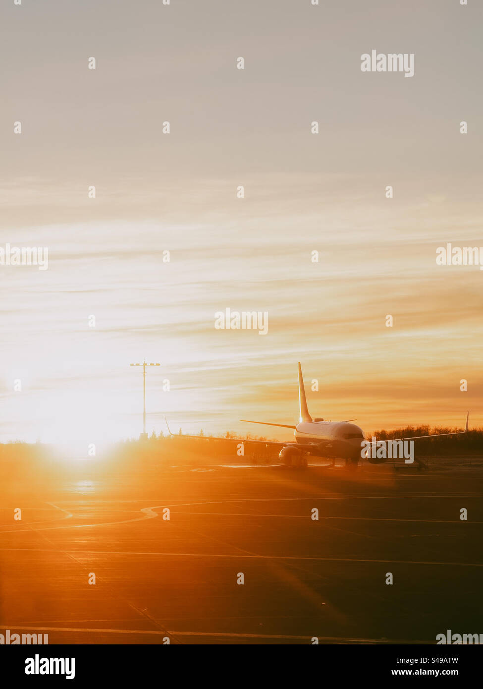 Aereo seduto sull'asfalto durante il tramonto - Immagine stock catturata con smartphone