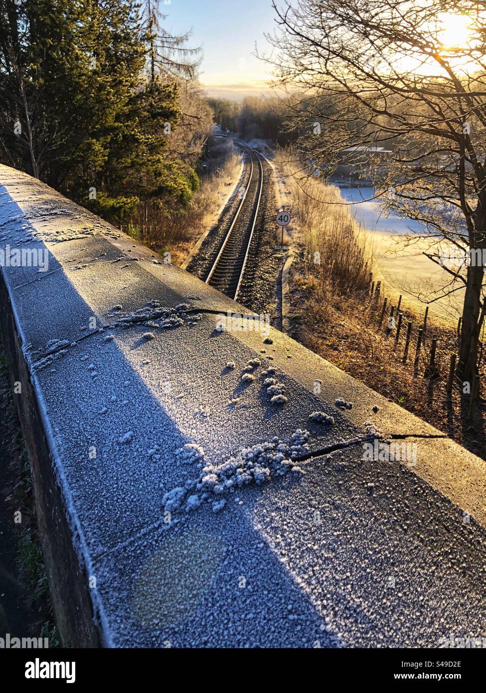 Ponte ferroviario e binari ferroviari congelati con gelo mattutino, Foto Stock