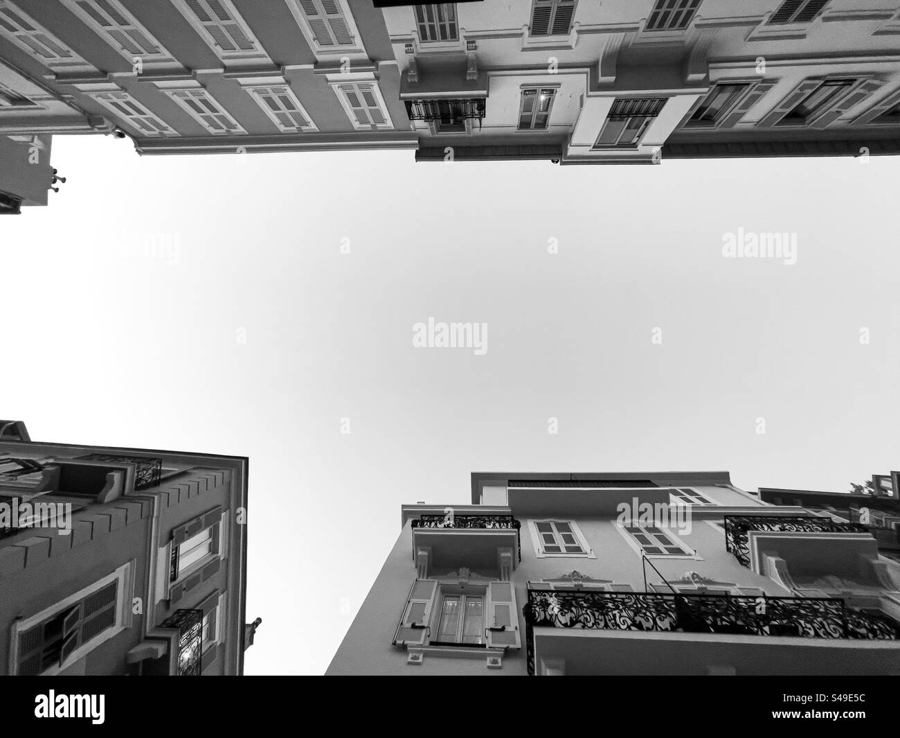 Vista ad angolo basso di una scena urbana con edifici e cielo in bianco e nero Foto Stock