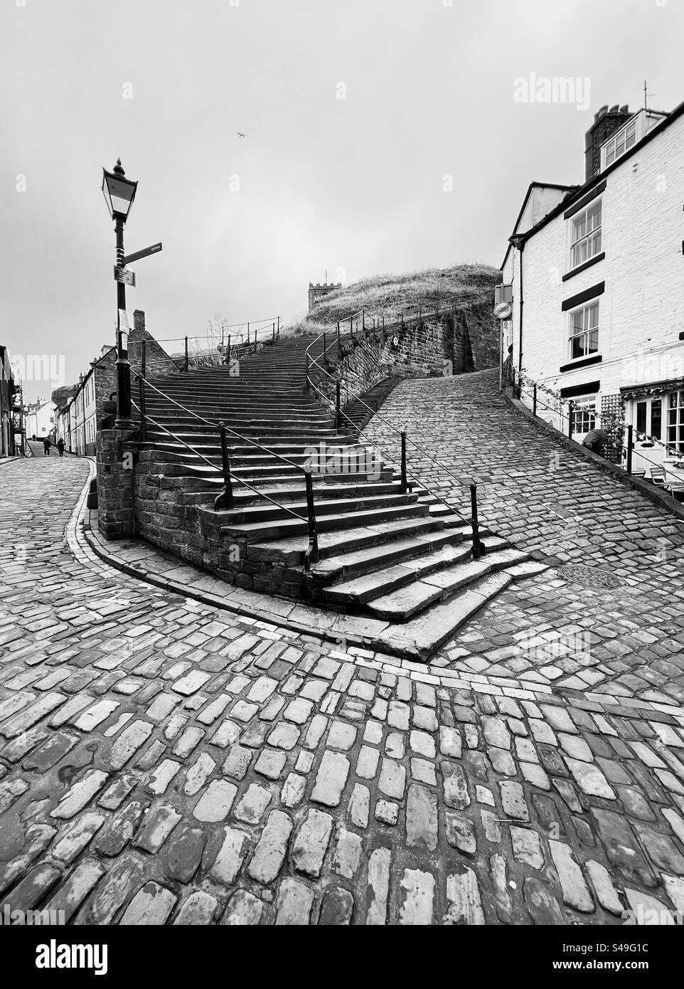 Strade acciottolate ai piedi dei 199 gradini di Whitby Foto Stock