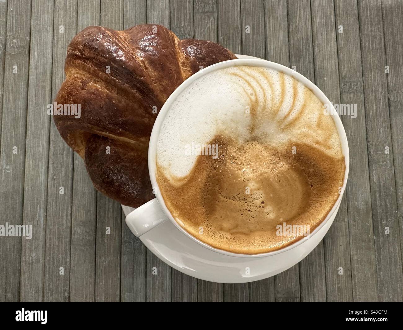 Classica colazione italiana per un dolce buongiorno al bar con croissant e cappuccino Foto Stock