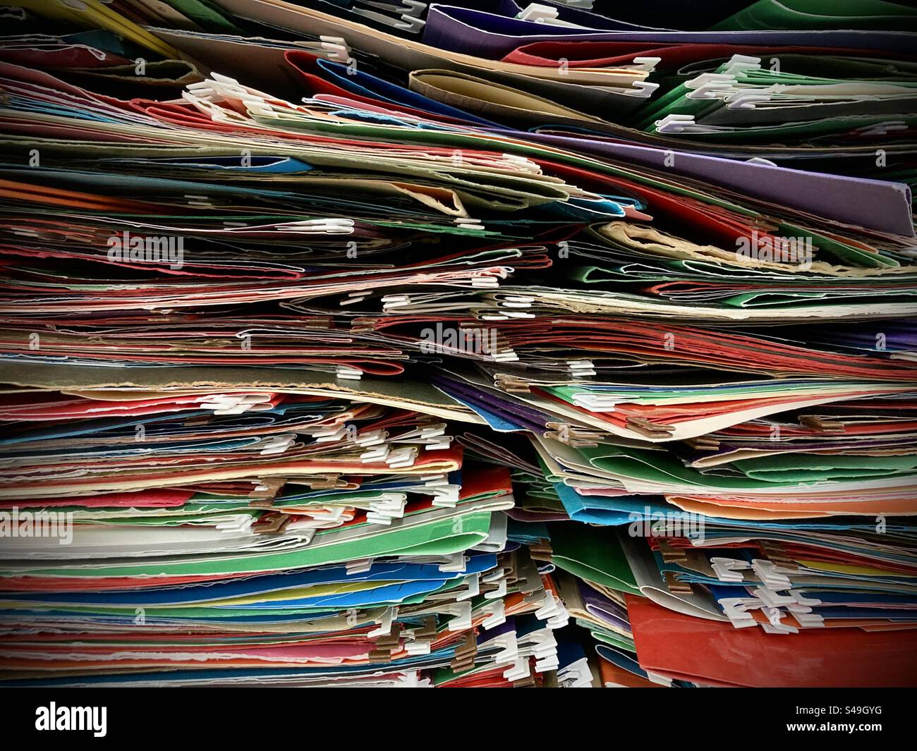 Una grande pila di cartelle di file colorate vuote. Foto Stock