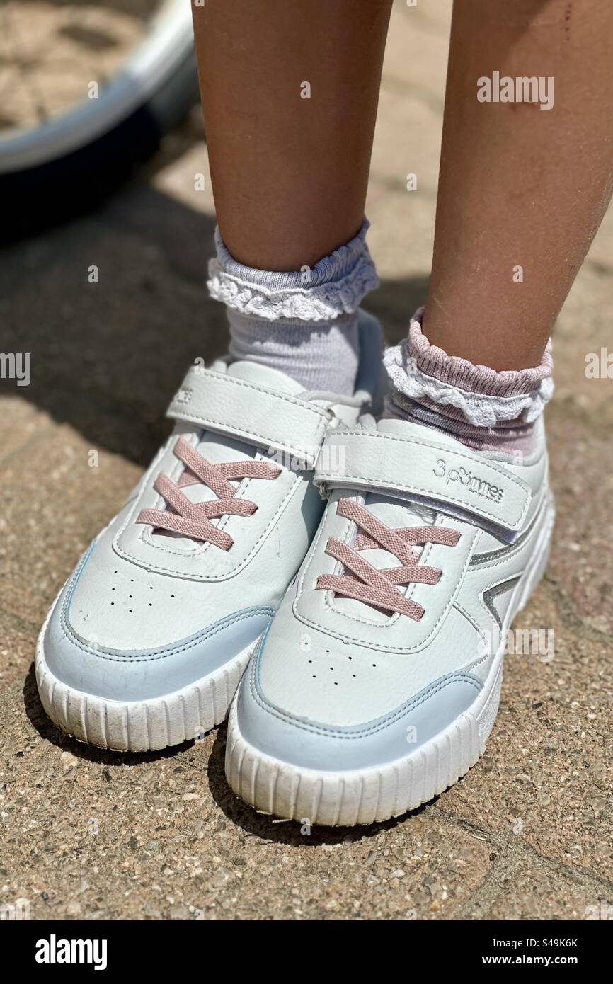Foto ravvicinata di un paio di sneakers bianche e rosa per bambini. Foto Stock