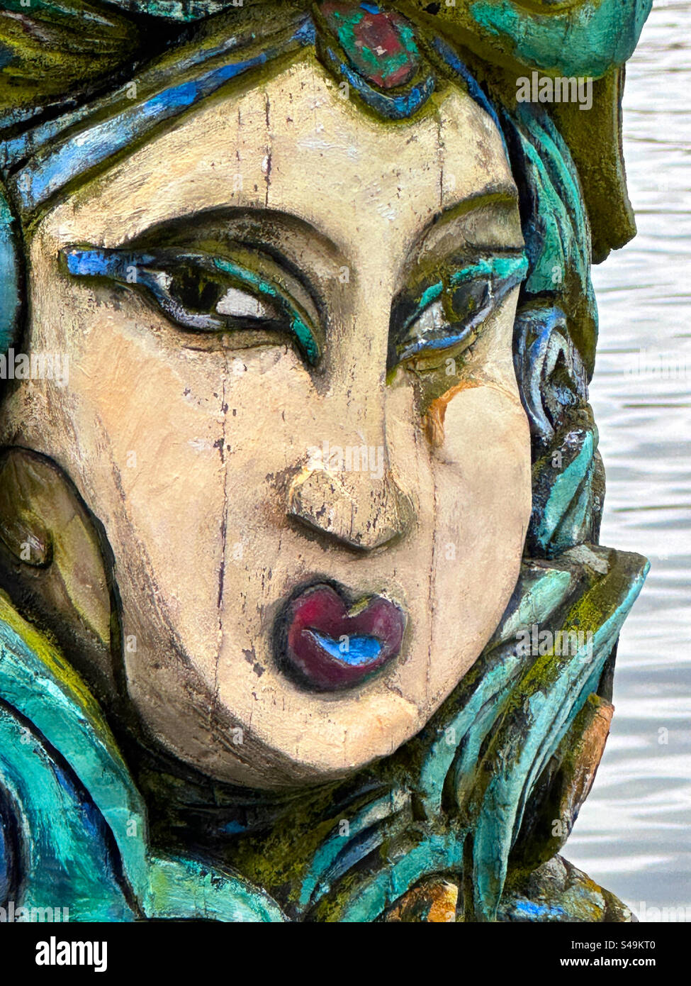 Un primo piano del volto su un totem scolpito scultura di Torsten Jurell sul lungofiume di Eriksberg, sull'isola di Hisingen, Gothenburg, Svezia. - Immagine stock catturata con smartphone