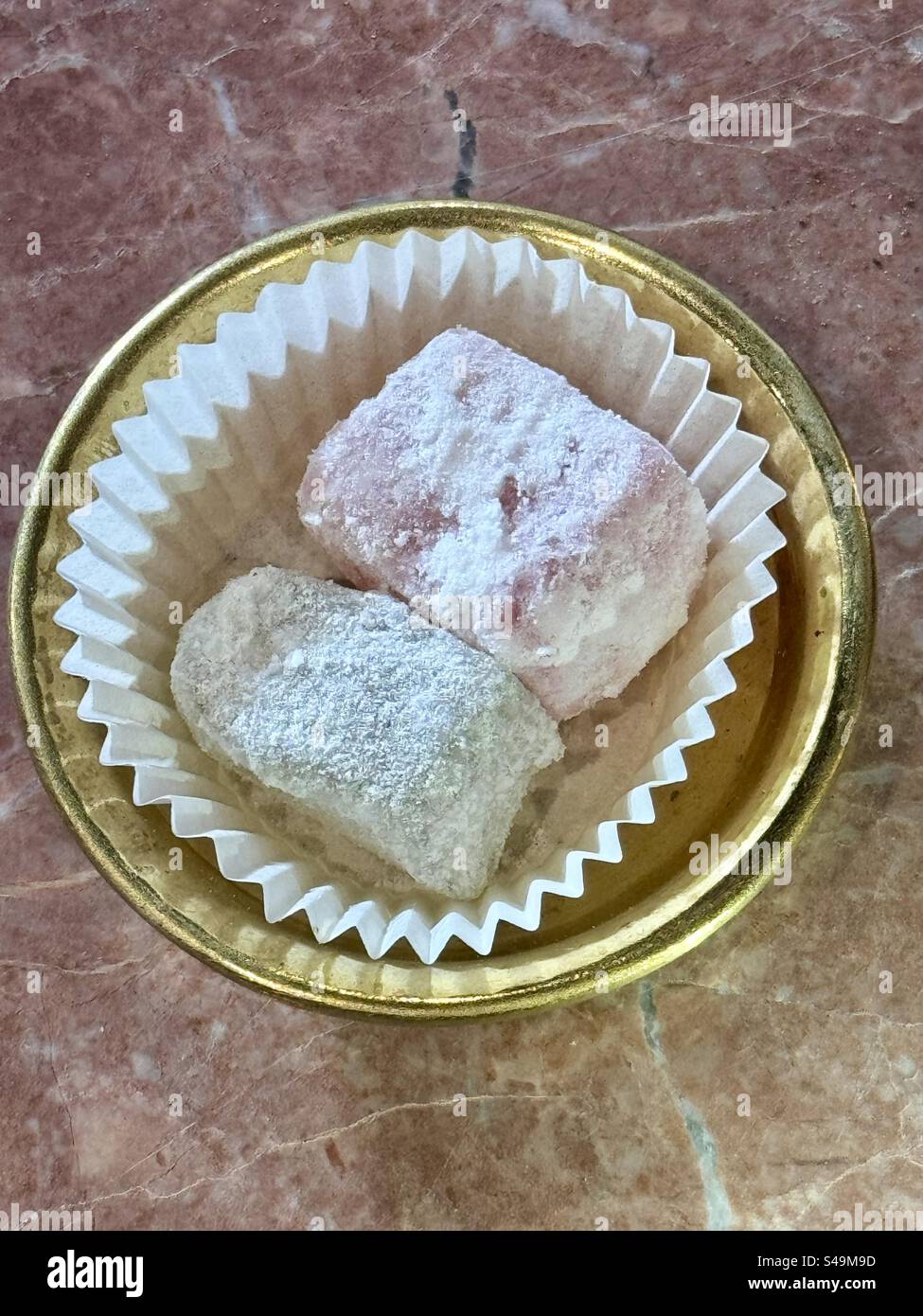 Primo piano dei tradizionali dolci greci Loukoumi con zucchero a velo in una tazza di carta, Atene, Grecia. - Immagine stock catturata con smartphone