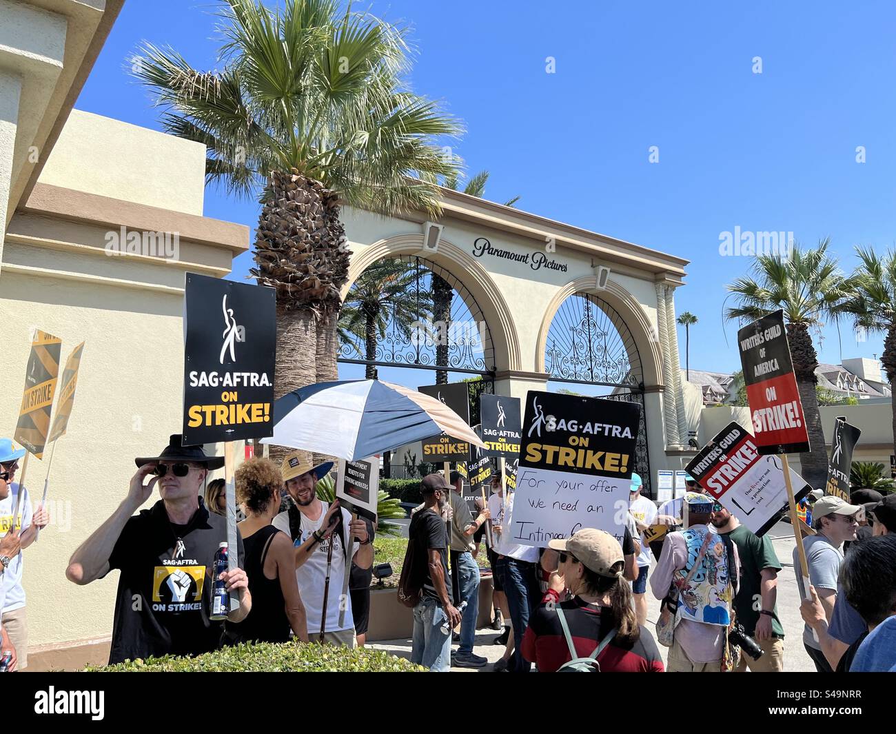 LOS ANGELES, CALIFORNIA, settembre 8, 2023: Sorprendenti attori SAG-AFTRA e scrittori WGA che portano cartelli e picchetto a piedi fuori dai cancelli dei Paramount Studios di Hollywood - Immagine stock catturata con smartphone