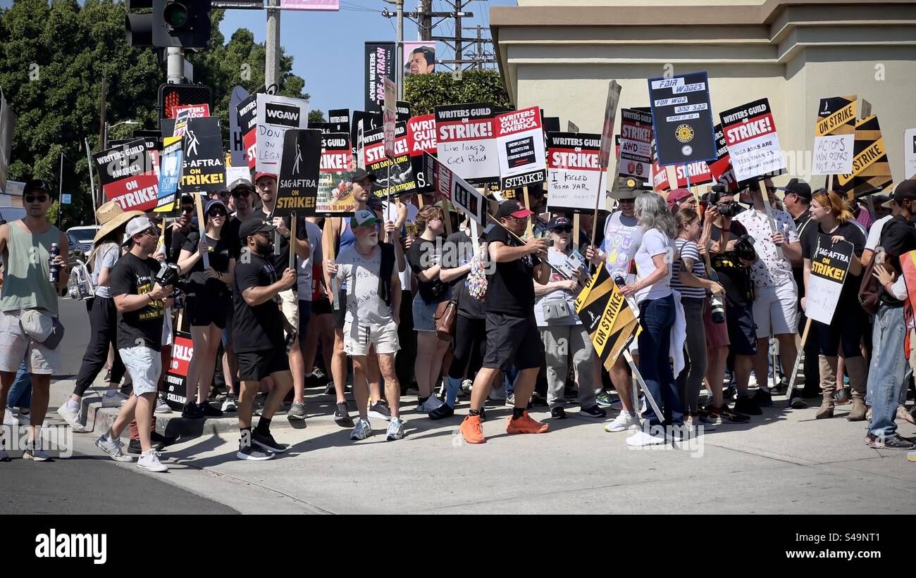 LOS ANGELES, CALIFORNIA, settembre 8, 2023: Un grande gruppo di insegne che portano scrittori WGA e attori SAG-AFTRA in sciopero, fuori dai cancelli dei Paramount Studios di Hollywood - Immagine stock catturata con smartphone