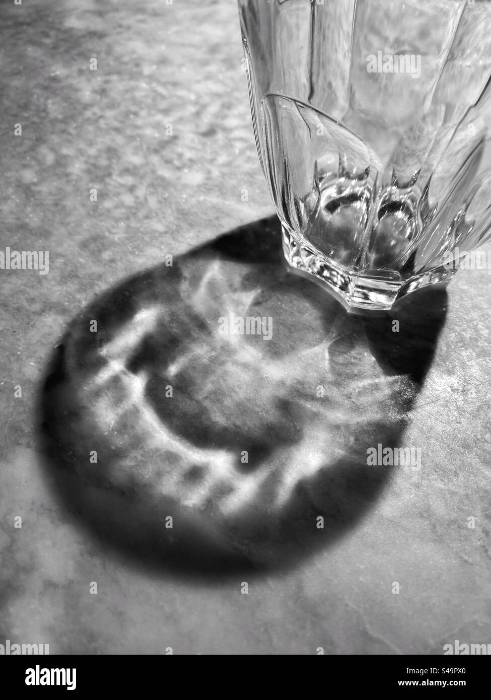 L'ombra di un bicchiere da bere su un tavolo di marmo. Un'immagine grafica con numerosi potenziali utilizzi? Foto ©️ COLIN HOSKINS. Foto Stock
