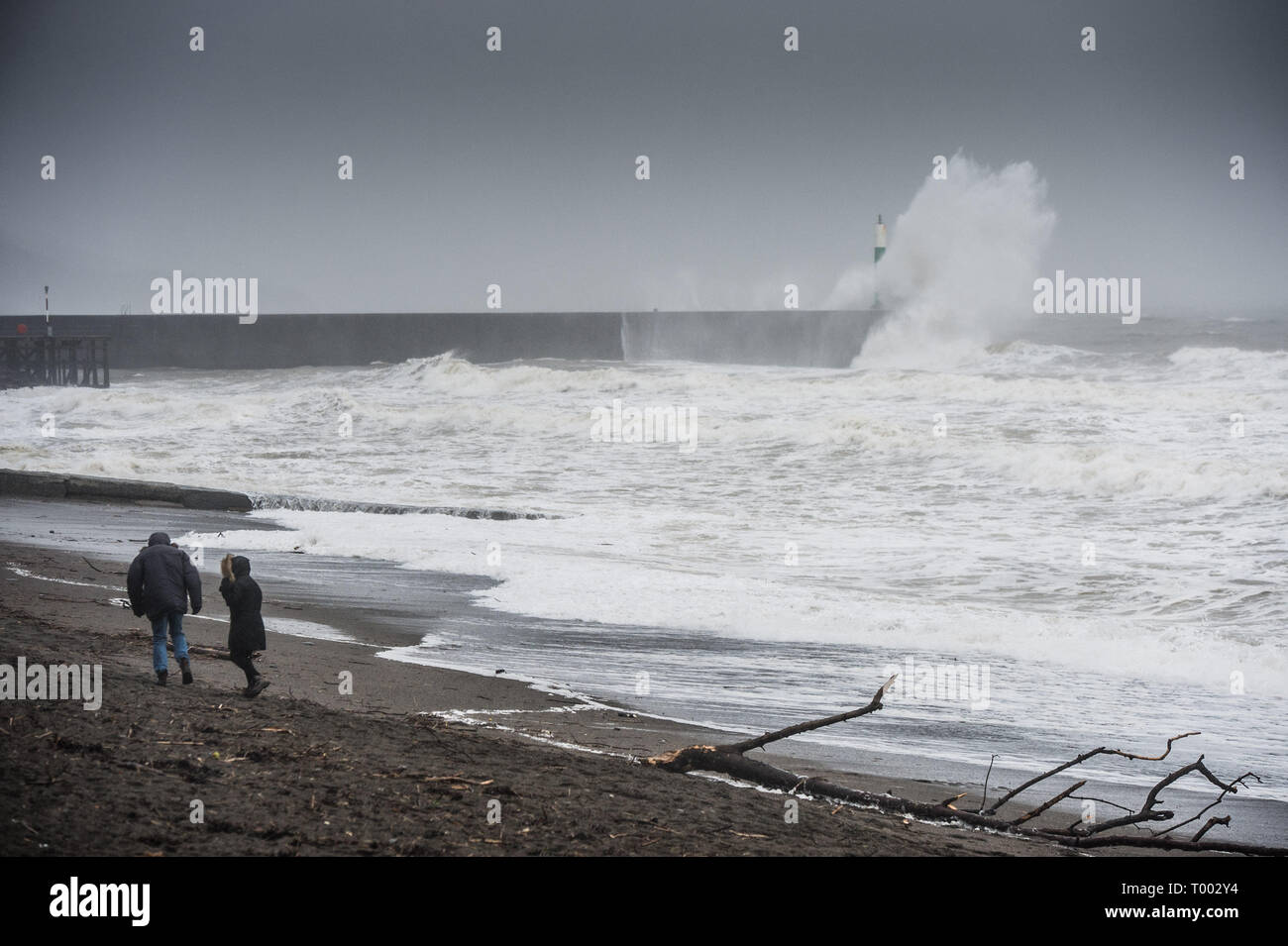Aberystwyth Regno Unito 16/03/2019 UK Meteo: Storm Hannah offre enormi onde che si infrangono nel faro del porto e le difese del mare su un estremamente bagnato e ventoso giorno in Aberystwyth Wales. Raffiche di oltre 50mph sono previsioni di impatto delle parti il nord e l ovest del paese oggi come il periodo di molto le perturbazioni atmosferiche continua a dominare il Regno Unito Photo credit: Keith Morris/Alamy Live News Foto Stock