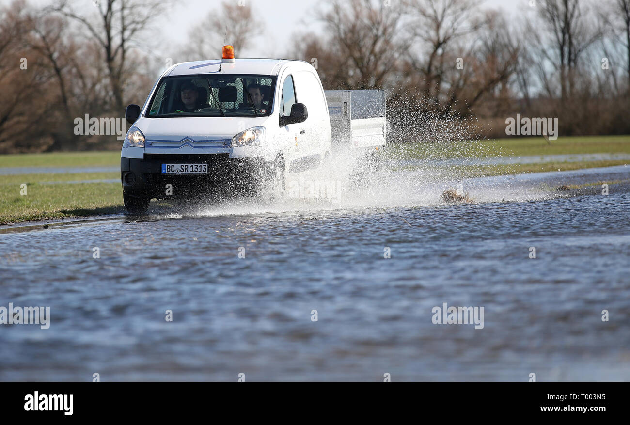 Daugendorf, Germania. 16 Mar, 2019. Un veicolo della città Riedlingen è su un modo inondate di mettere fino a diluvio cartelli di avvertimento. Il Danubio ha traboccato le sue rive. Credito: Thomas Warnack/dpa/Alamy Live News Foto Stock