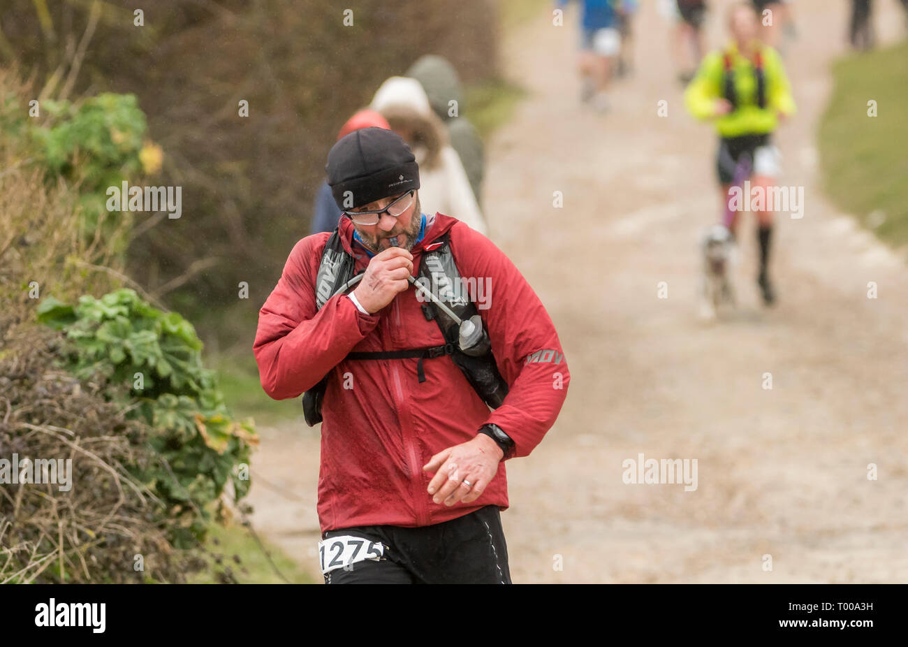 Birling Gap, East Sussex, Regno Unito. 16 marzo 2019. Nonostante il forte vento e pioggia da Storm Gareth come si batte il Regno Unito, i concorrenti a tutti i livelli la faccia esposta alte scogliere di Beachy Head sulla costa sud dell'Inghilterra per prendere parte a una serie di durata di vita agli eventi di gara. 4 gli eventi consistono di un 10km, di mezza maratona e per la maggior parte determinata dei corridori il 34.1 miglio Ultra evento. La ruvida terreni scoscesi rappresenta uno dei più impegnativi marathon corsi nel Regno Unito ha reso tutti più impegnativi nel feroce condizioni atmosferiche. Foto Stock